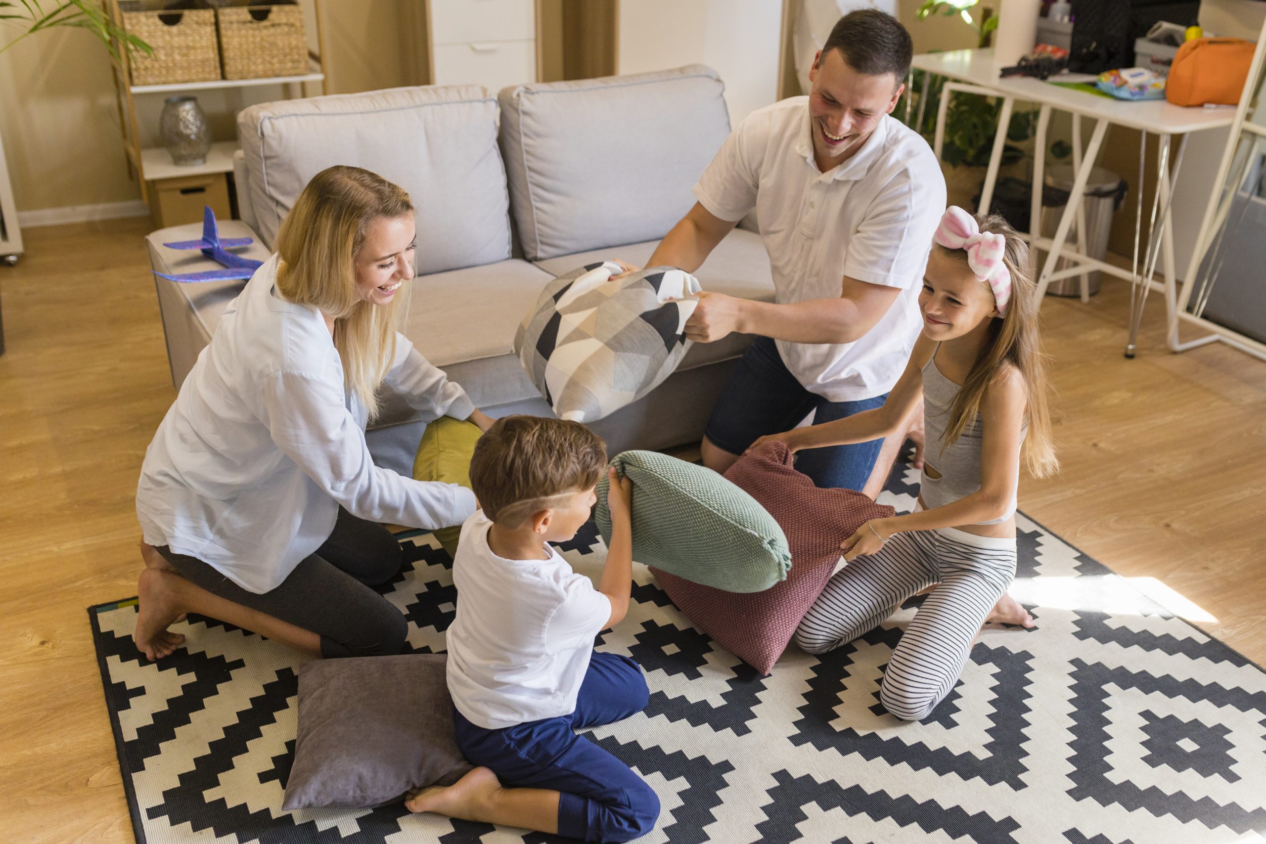 high-view-family-playing-living-room-with-pillows